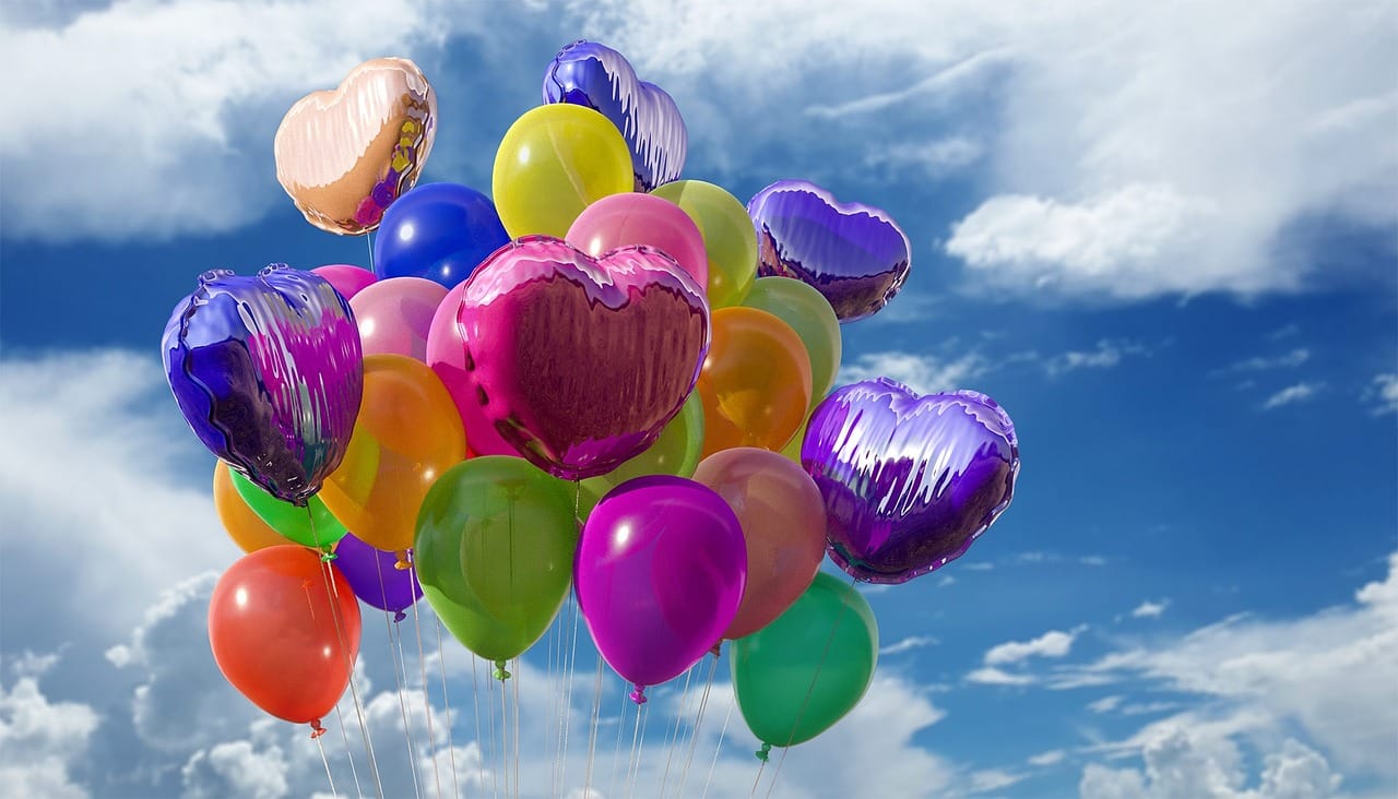 Des ballons colorés dans un ciel nuageux