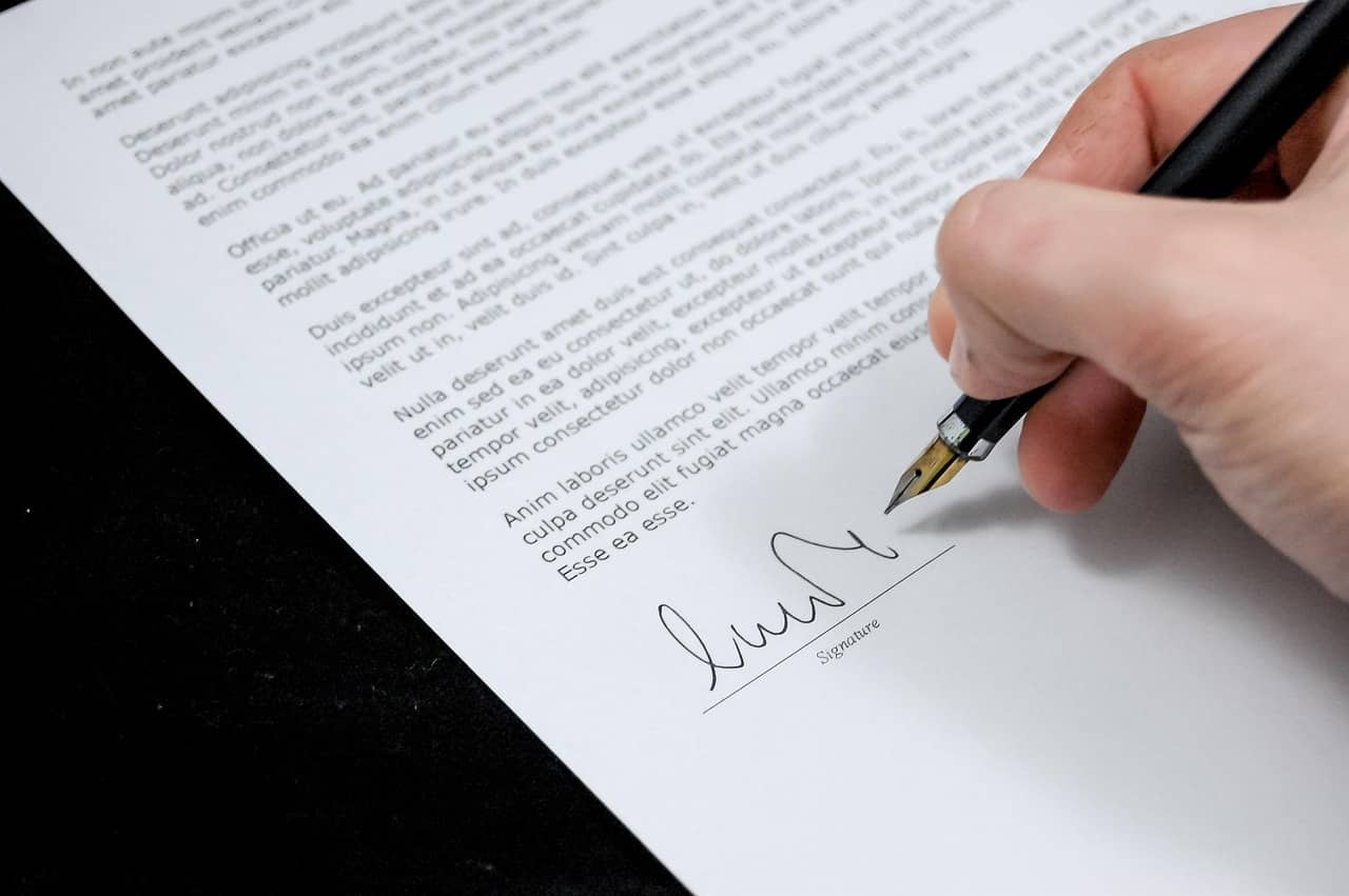 Une main signe un document