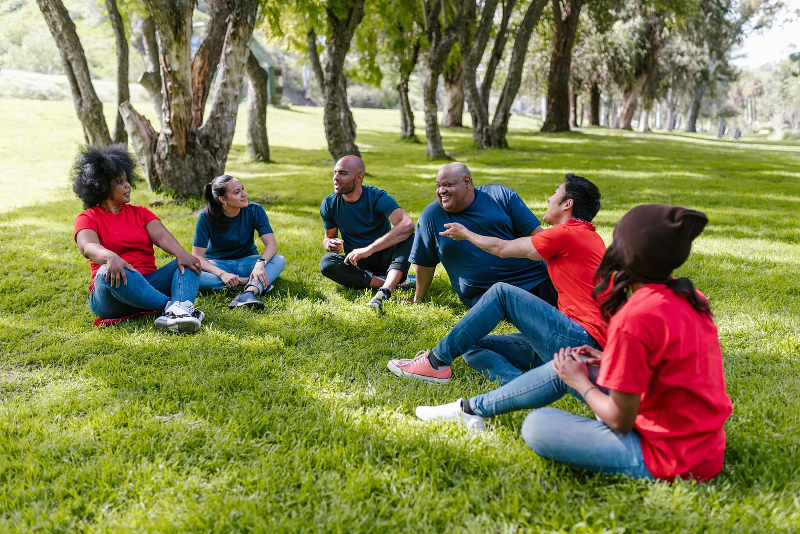 Des personnes assises sur l'herbe en train de discuter : des bénévoles mobilisées